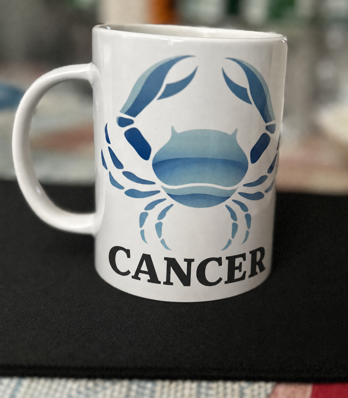 White mug with a blue Cancer crab design and the word Cancer